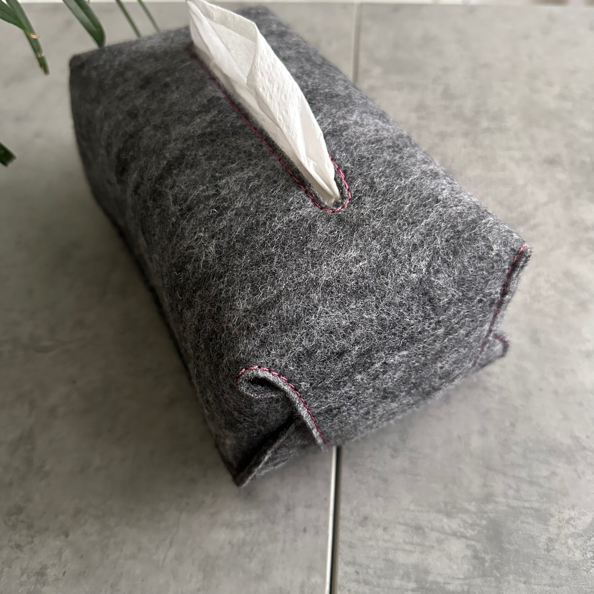 Gray textured tissue holder with pink stitching
